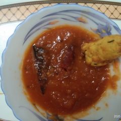 A picture of Potato Cutlet Dip In Tomato Sauce.