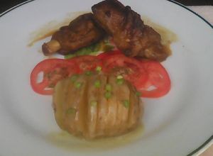 Una foto de Costilla de cochino con papa acordeón