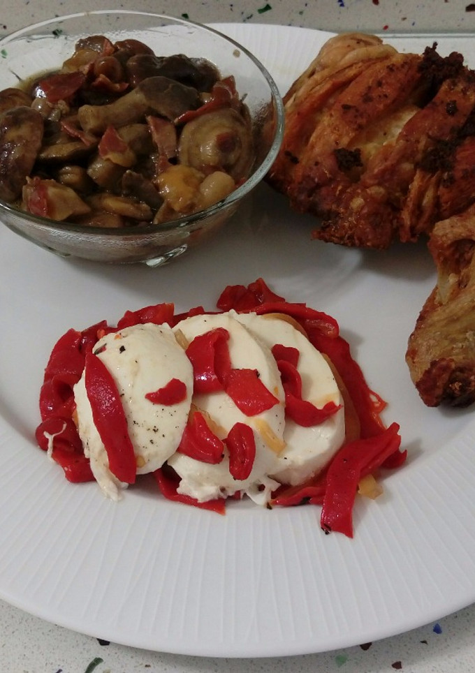 Una foto de Traseros de pollo frito con setas salteadas con jamón y mozzarella con pimientos asados