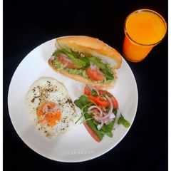 A picture of Avocado Sandwich with Sunnyside Egg and Orange Juice.