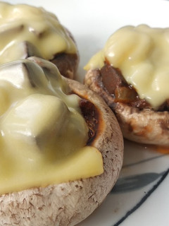Una foto de Champiñón con queso, relleno de sangre encebollada con tomate