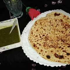 A picture of Aloo bhara paratha with green. Imli chutney.