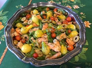 Une photo de Salade de roquette aux crevettes, tomates, olives et ail
