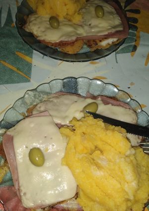 Una foto de Milanesa de merluza a la pizza y guarnición de papas ycalabaza