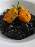 Arroz negro meloso con garbanzos y merluza rebozada
