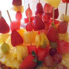 A picture of Edible fruit arrangement on a pineapple boat.