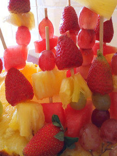 A picture of Edible fruit arrangement on a pineapple boat.