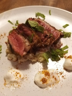 A picture of Duck breast with Indian spice rub on cauliflower coconut puree.