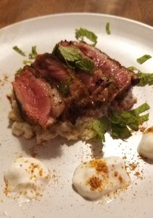 A picture of Duck breast with Indian spice rub on cauliflower coconut puree.