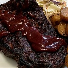 A picture of St. Louis "inspired" pork steaks, BBQ sauce, and potatoes.