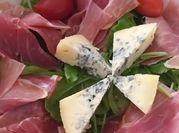 Una foto de ensalada rucula roquefort