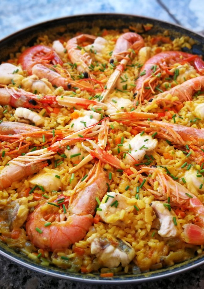 Una foto de Paella con marisco y rape a la cúrcuma