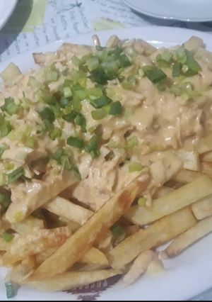 Una foto de Papas con cheddar y verdeo
