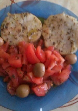 Una foto de Rodajas de merluza, con ensalada de tomate