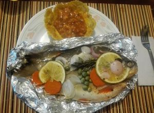 Una foto de Cachamas en sus jugos con verduras y naranja acompañada de ceviche de mango en canastilla de plátano