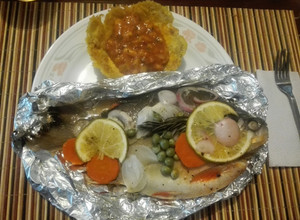 Una foto de Cachamas en sus jugos con verduras y naranja acompañada de ceviche de mango en canastilla de plátano