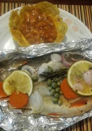 Una foto de Cachamas en sus jugos con verduras y naranja acompañada de ceviche de mango en canastilla de plátano