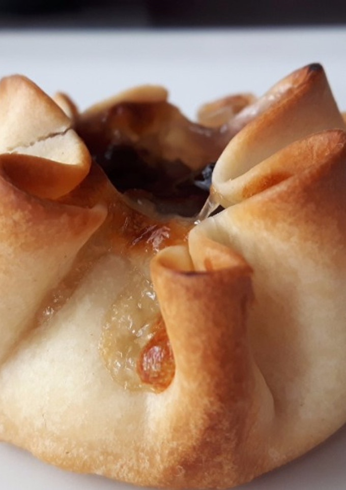 Una foto de Saquitos de queso y cebolla caramelizada