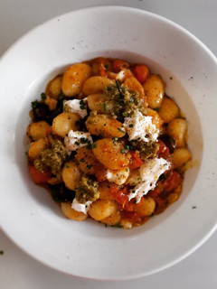 Una foto de Gnocchis picante al pesto con cherrys, olivas negras y mozzarella