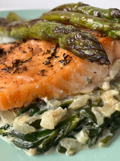 A picture of Baked Salmon with Asparagus on a Bed of Creamed Spinach.
