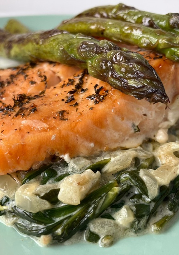 Una foto de Salmón al horno con espárragos sobre cama de espinacas a la crema