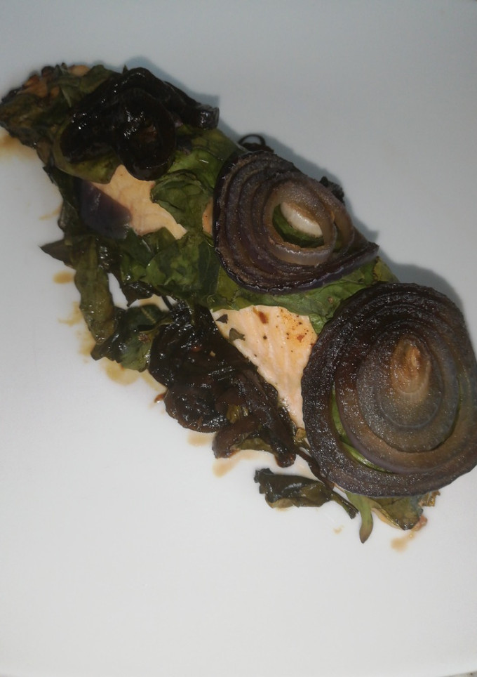 Una foto de Salmón con espinacas y cebolla morada
