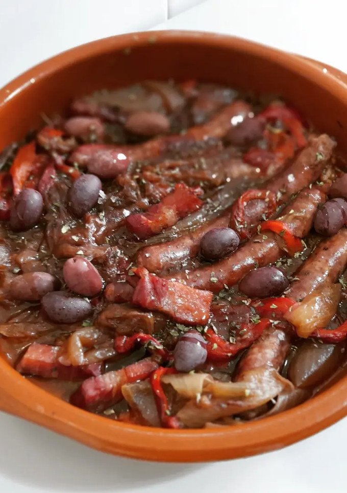 Una foto de Salchichas y panceta al vino con escalivada y kalamatas