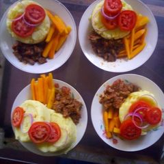 A picture of Mashed potatoes,brown lamb stew and buttered carrot.