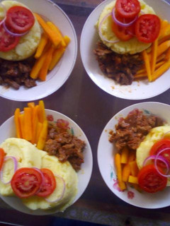 A picture of Mashed potatoes,brown lamb stew and buttered carrot.