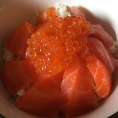 A picture of Ikura and Salmon sashimi on rice.