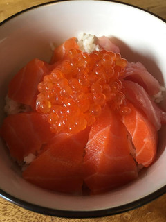 A picture of Ikura and Salmon sashimi on rice.