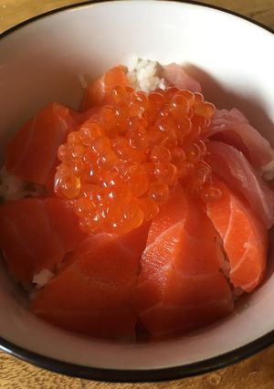A picture of Ikura and Salmon sashimi on rice.
