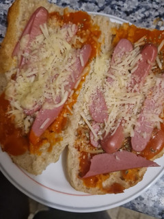 Una foto de Paninis caseros con salchichas y quesos rallados