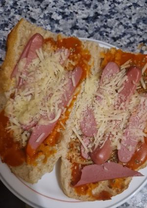 Una foto de Paninis caseros con salchichas y quesos rallados