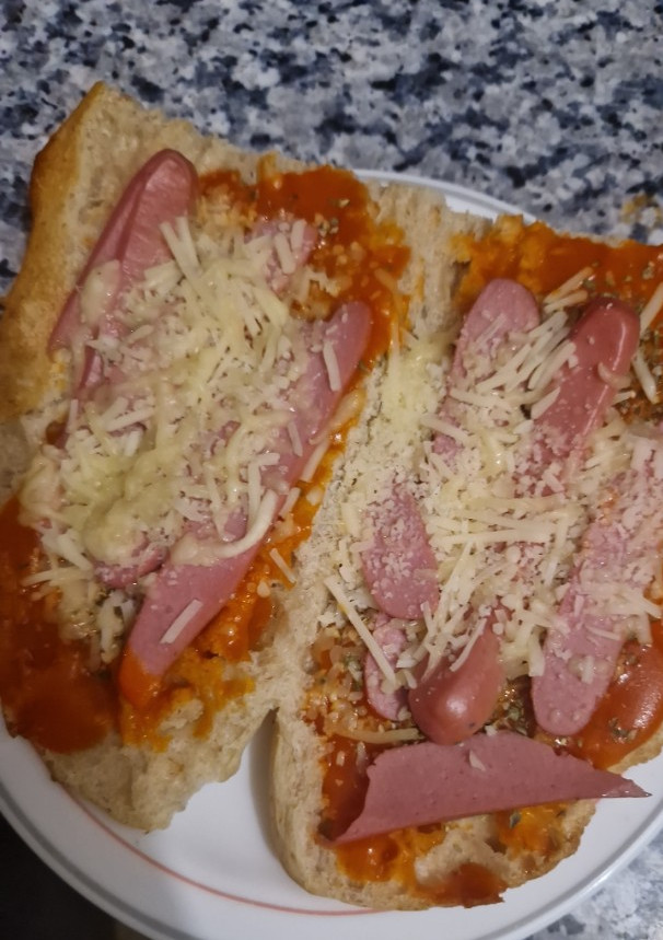 Una foto de Paninis caseros con salchichas y quesos rallados
