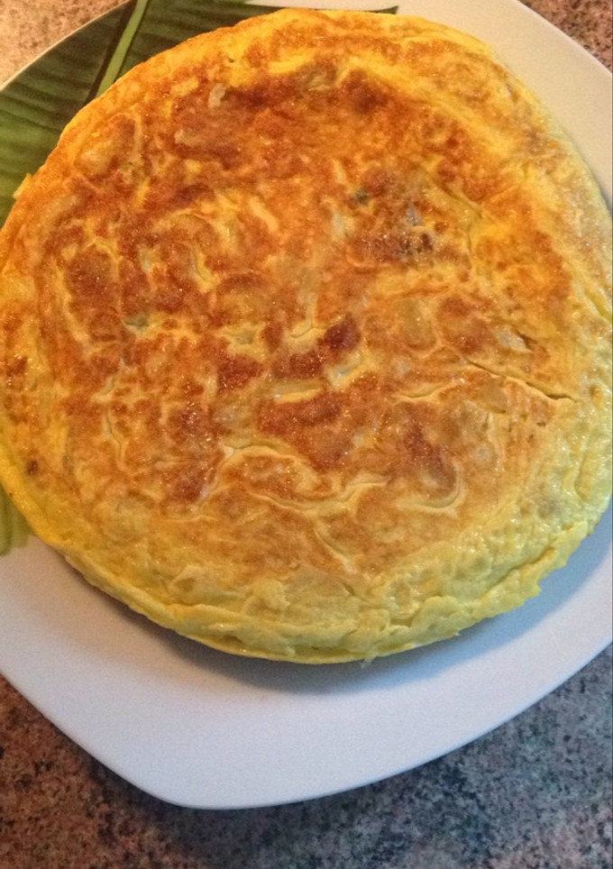 Una foto de Tortilla de patata con cebolla y huevos camperos