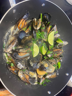 Una foto de Mejillones con leche de coco, lima, curry y perejil