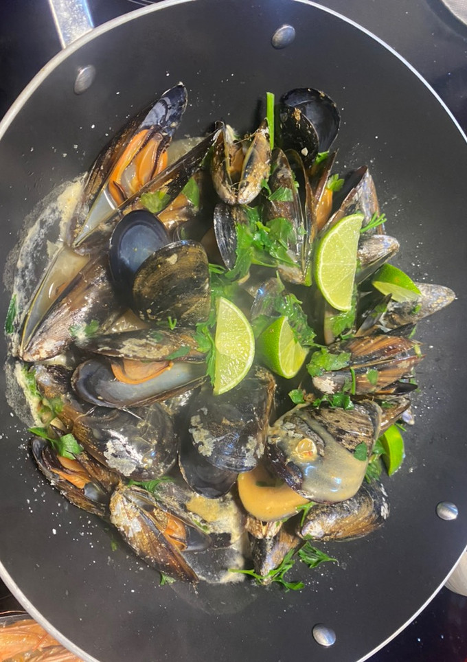 Una foto de Mejillones con leche de coco, lima, curry y perejil