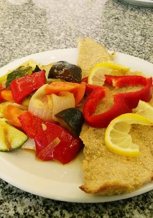 Una foto de Filet de Merluza rebozada con verduras al horno