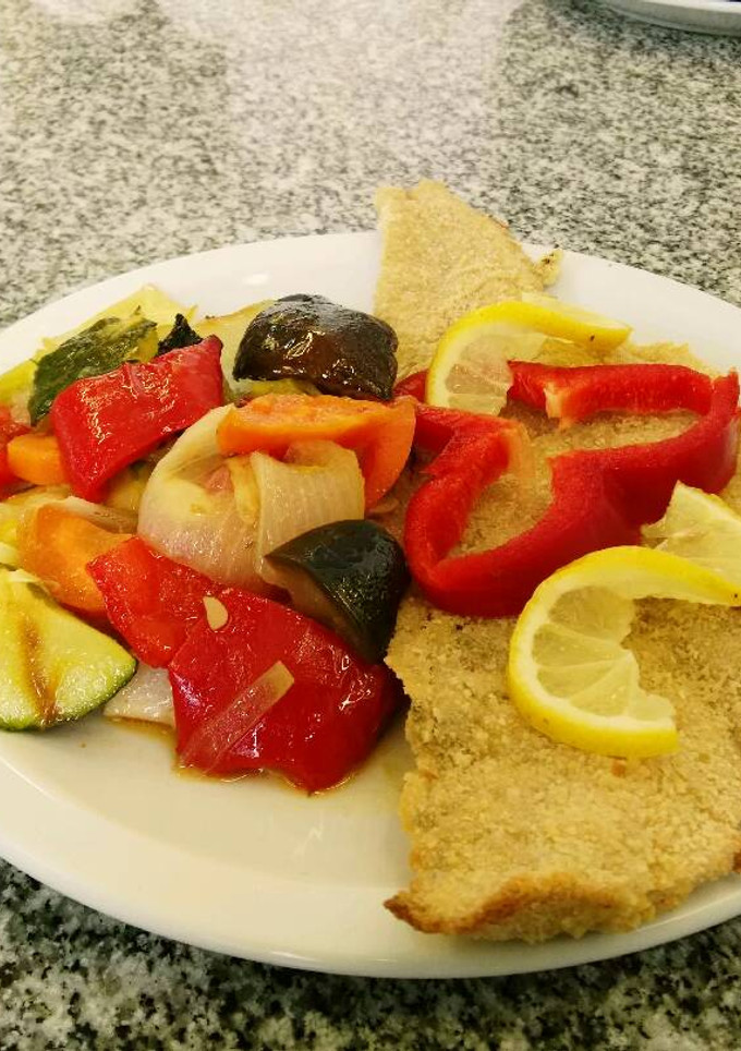 Una foto de Filet de Merluza rebozada con verduras al horno