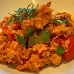 A picture of Spanish style tomato and chicken baked rice.