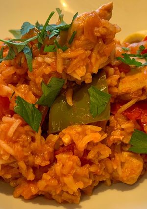 A picture of Spanish style tomato and chicken baked rice.