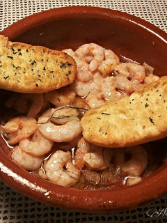 Una foto de Gambas al ajillo con aceite dargan y ajos rojos morunos