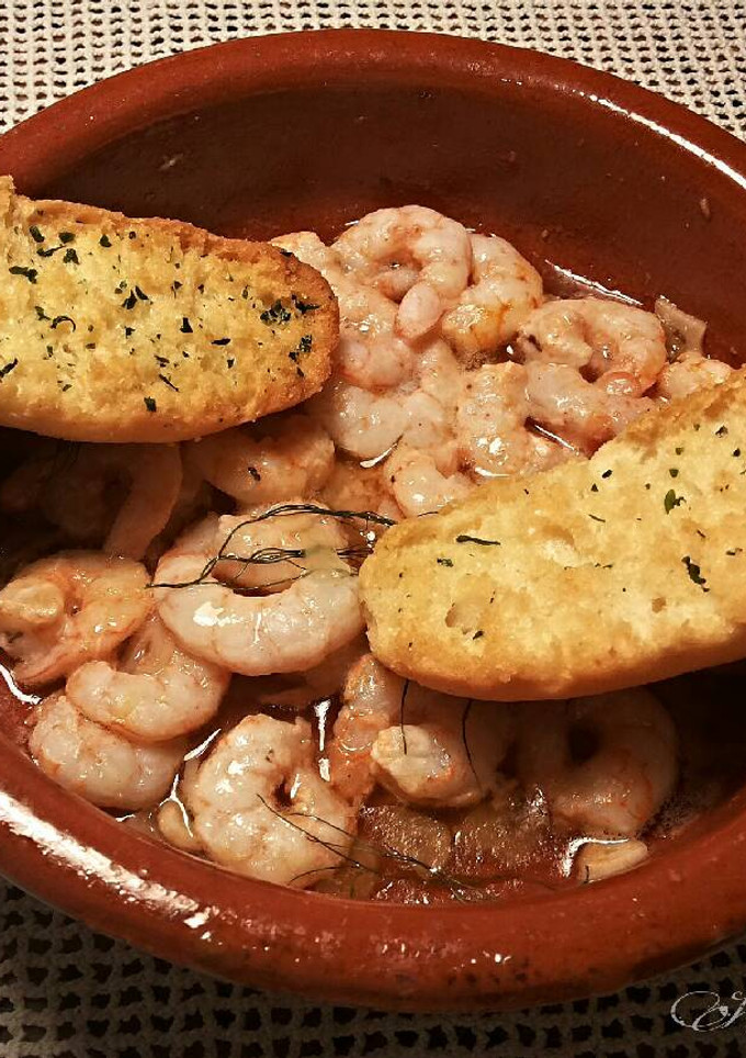 Una foto de Gambas al ajillo con aceite dargan y ajos rojos morunos