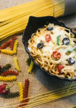 A picture of Spaghetti with cheese and pepper.