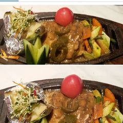 A picture of Chicken Steak with mushrooms sauce.