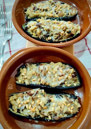 Una foto de Berenjena gratinada con piñones rellena de setas