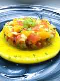 Tartare di salmone con arancia, sedano, mela verde e granella di pistacchi, su gazpacho di mango