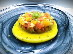 Foto di Tartare di salmone con arancia, sedano, mela verde e granella di pistacchi, su gazpacho di mango