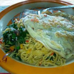A picture of Garnished Noddle's with pumpkin leaf and egg.